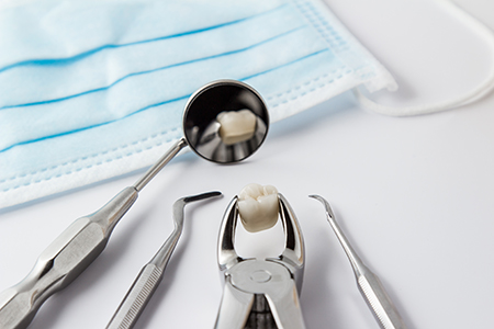 This image shows dental tools including a dental mirror with a toothbrush inside it, placed on a table with blue gauze underneath, suggesting a dental care setting.